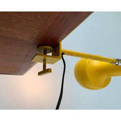 a yellow light that is on the side of a wooden ceiling with a white wall behind it