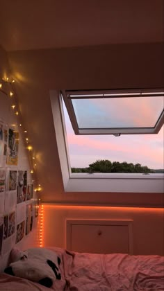 a bedroom with a skylight above the bed and pictures on the wall behind it