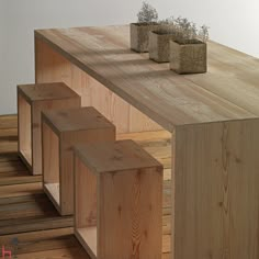 three wooden planters sitting on top of a wood shelf next to eachother