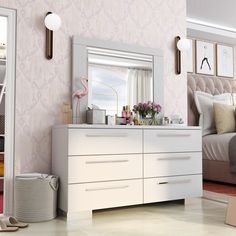 a white dresser sitting next to a bed in a bedroom