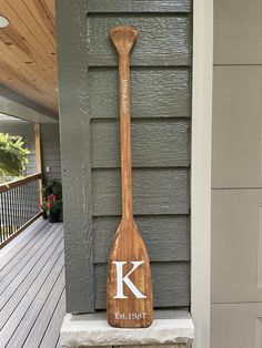 a wooden paddle with the letter k on it sitting in front of a door way