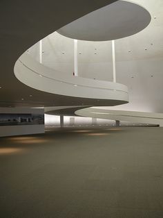 the interior of an empty building with white walls and ceiling lights on either side of the room