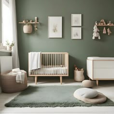 a baby's room with green walls and white furniture, including a crib