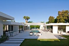 an outdoor patio with chairs and tables next to a swimming pool