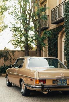 an old mercedes parked in front of a house