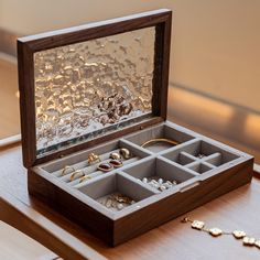 an open jewelry box sitting on top of a wooden table