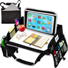 an ipad sitting on top of a desk next to a book bag and pencils