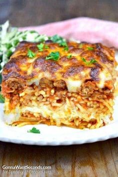 a white plate topped with lasagna covered in cheese