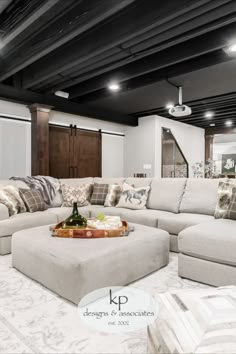 a living room filled with lots of furniture and pillows on top of a white rug