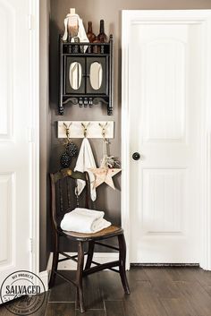 a room with a chair, mirror and shelf on the wall next to a door