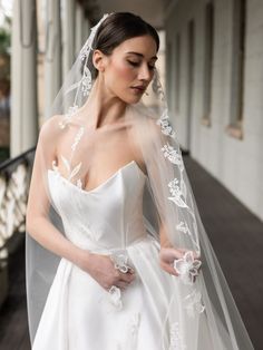 a woman in a wedding dress with a veil on her head