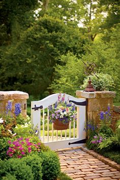 a garden gate with flowers and plants growing on it