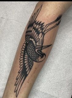 a black and white bird tattoo on the arm