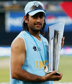 a man with long hair holding a metal object in one hand and wearing a baseball cap on the other