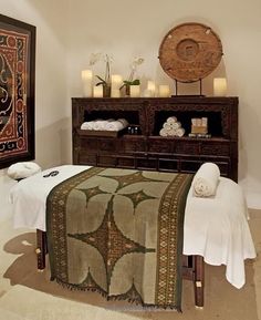 a spa room with towels and candles on the table