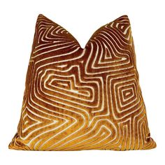 a brown and white pillow with an abstract design on it's side, against a white background