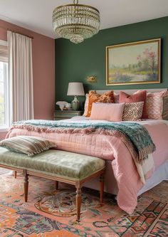 a bedroom with green walls, pink bedding and a chandelier hanging from the ceiling