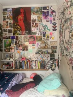 a bed with lots of books and pictures on the wall next to it in a bedroom