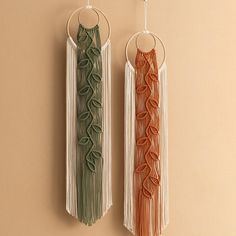 two wall hangings made out of macrame and yarn with rings on them