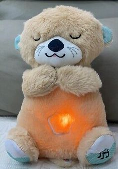 a teddy bear holding a lit candle in its paws