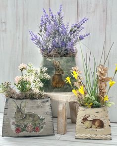 three wooden boxes with flowers and rabbits in them