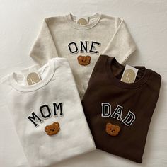 three t - shirts with teddy bears on them that say one mom, one dad