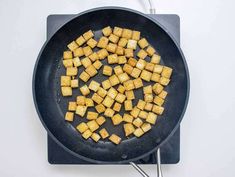 cubed food being cooked in a frying pan