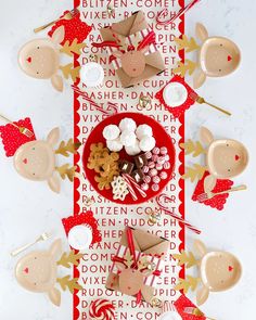 a table topped with lots of different types of candy and candies next to cupcakes