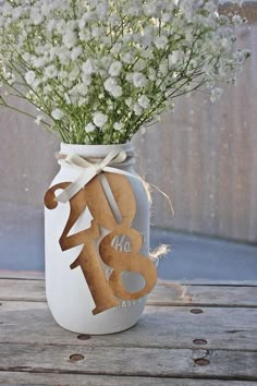 a mason jar filled with baby's breath flowers on top of a wooden table