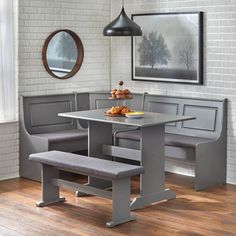 a kitchen table with two benches in front of it and a mirror on the wall