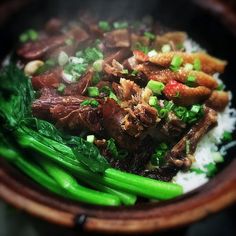 a wooden bowl filled with meat and vegetables