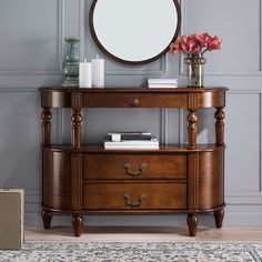 a wooden dresser with drawers and a mirror on the wall above it in a living room