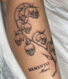 a woman's leg with skulls and flowers on it