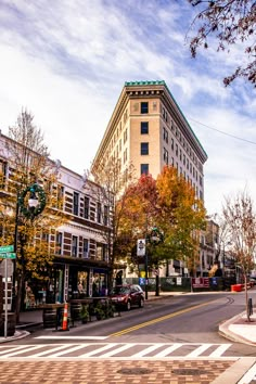 a city street with tall buildings on both sides and trees in the middle of it