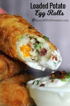 an egg roll is being held up to show the filling on it's side