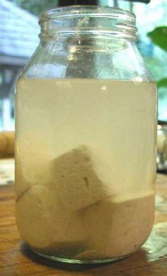 a jar filled with rocks sitting on top of a wooden table