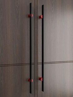 two wooden doors with black handles and red knobs