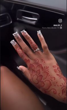 a woman's hand with tattoos on it sitting in the drivers seat of a car