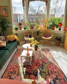 a living room filled with furniture and lots of plants in the window sills