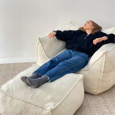 a woman is laying on a bean bag chair