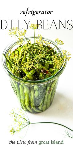 a glass bowl filled with green beans on top of a table