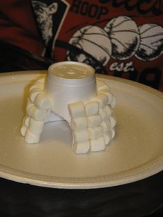 a white plate topped with marshmallows on top of a table