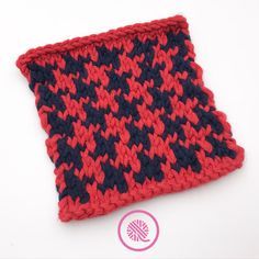 a red and black knitted dishcloth sitting on top of a white table