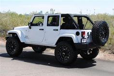 a white jeep is parked on the side of the road