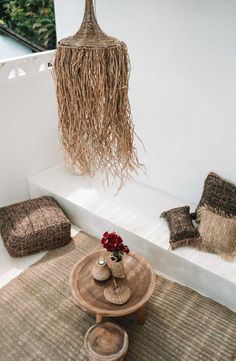 a table with two vases on top of it next to some pillows and blankets