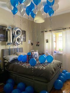 balloons and streamers fill the air above a bed in a bedroom decorated for a 30th birthday