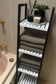 a bathroom with a sink, towel rack and bathtub in it's corner