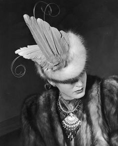 a woman in a fur coat and feather hat