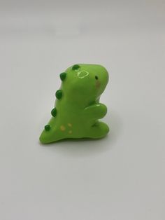 a green toy sitting on top of a white table