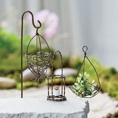 three metal bird cages with plants in them and the words wire accessories written below it